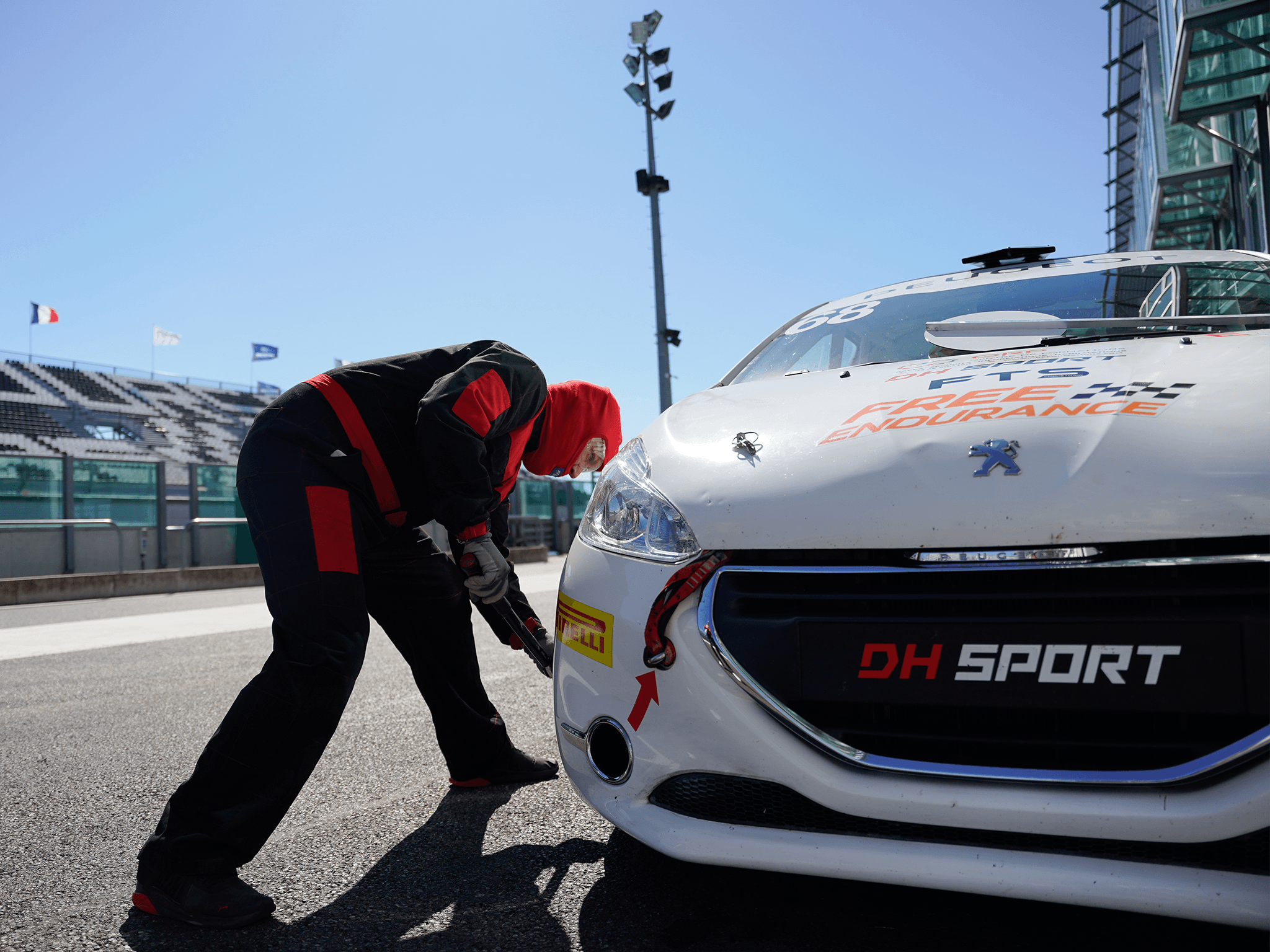 Mécanicien de DH Sport changeant les pneus d'une 208 racing lors d'un arrêt au stand d'une 208 racing cup