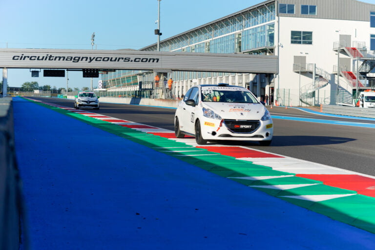 Peugeot 208 de DH Sport devant une Clio Cup en course sur le circuit de Magny-Cours